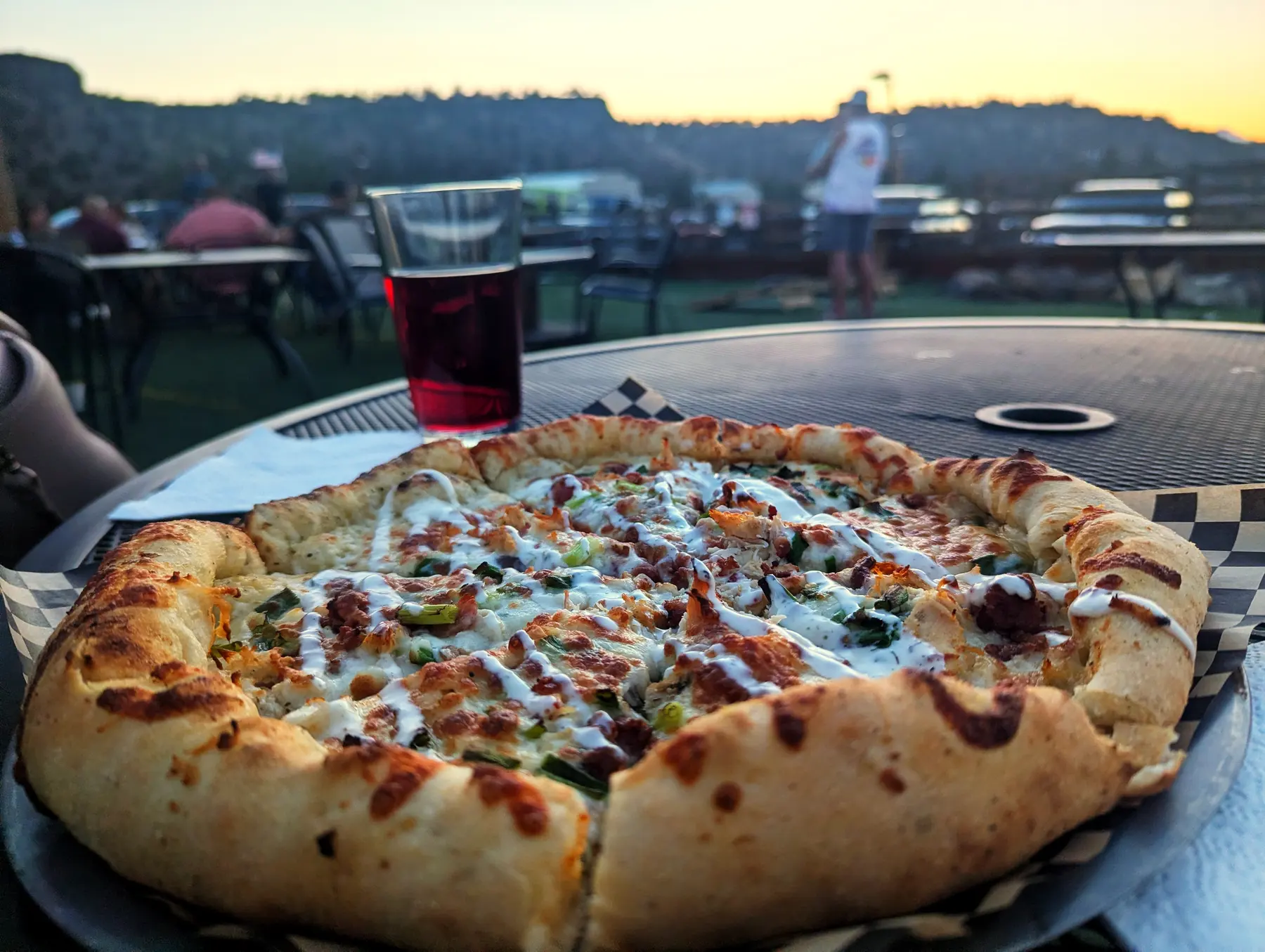 A scratch-sourdough pizza on a table at Over The Edge Taphouse, with the Crooked River canyon rim behind it.